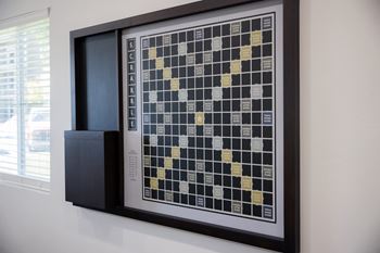 A Scrabble board with tiles on it and a speaker next to it.